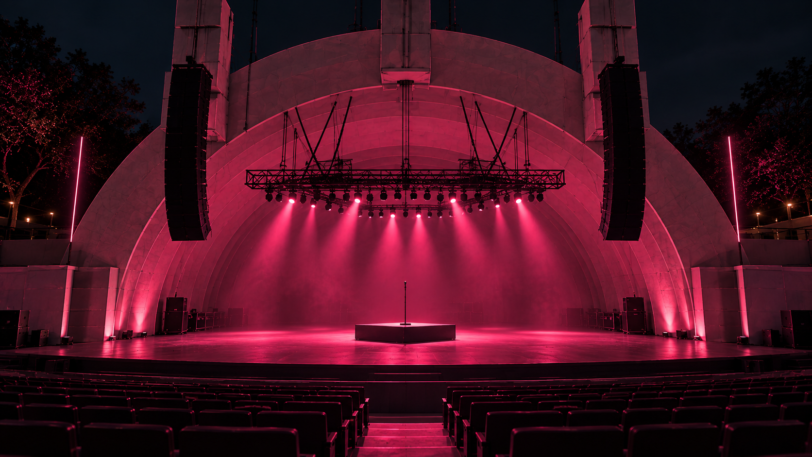 Concert venue — the band shell from the audience, pink-lit, empty